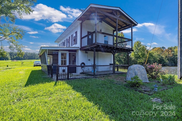 rear view of house with a yard and a deck