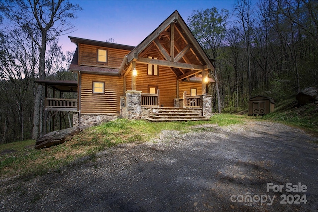 exterior space with covered porch and a shed