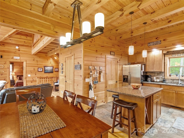 tiled dining room featuring wooden walls, sink, beamed ceiling, and wooden ceiling