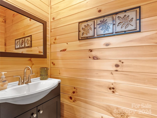 bathroom featuring large vanity and wood walls