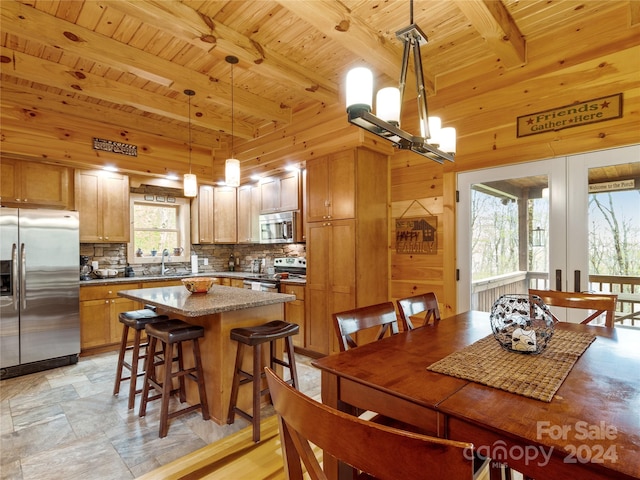 dining space featuring beam ceiling, wooden ceiling, sink, and light tile flooring