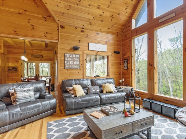 living room with a wealth of natural light, wood walls, hardwood / wood-style floors, and wood ceiling