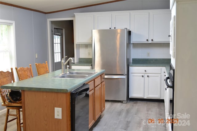 kitchen featuring light hardwood / wood-style floors, tasteful backsplash, stainless steel refrigerator, and black dishwasher