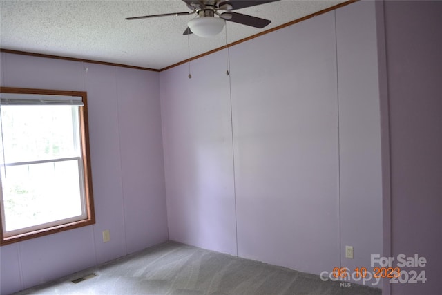 carpeted empty room featuring a textured ceiling and ceiling fan