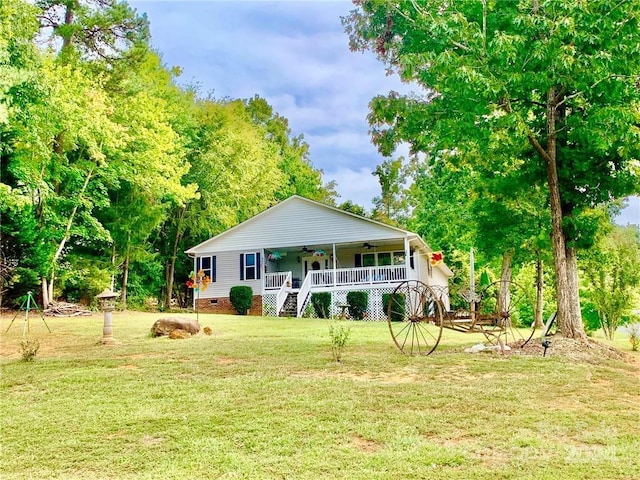 rear view of house featuring ceiling fan and a lawn