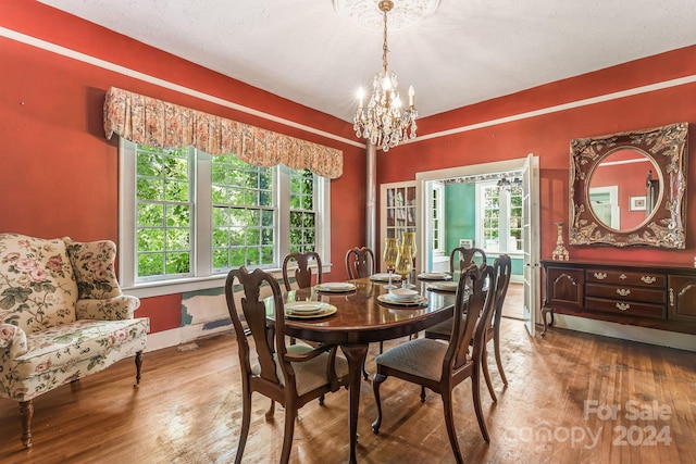 dining area with hardwood / wood-style flooring, an inviting chandelier, and a healthy amount of sunlight