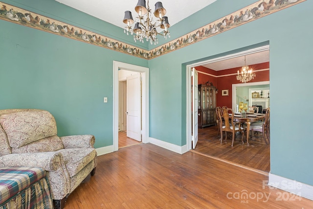 living area with hardwood / wood-style flooring and an inviting chandelier