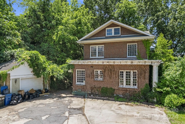 view of front of home featuring a garage and an outbuilding