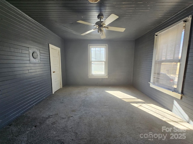 unfurnished room with ceiling fan and carpet flooring