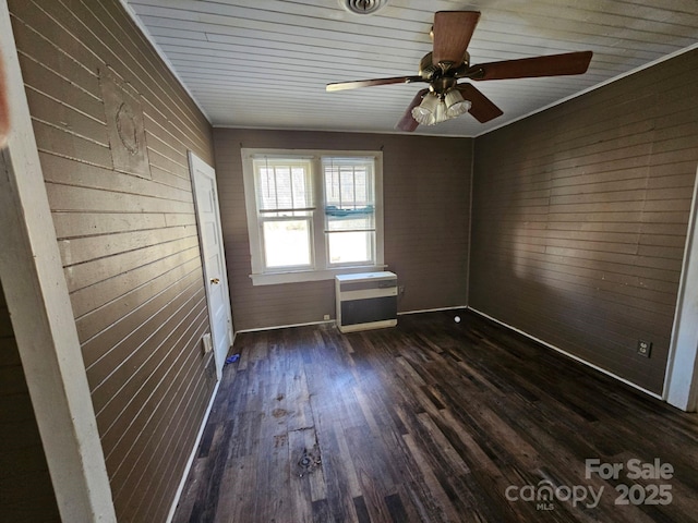 unfurnished room featuring wood walls, ceiling fan, and dark hardwood / wood-style flooring