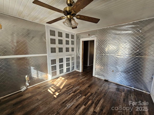 unfurnished living room with ceiling fan, wood ceiling, and dark hardwood / wood-style floors