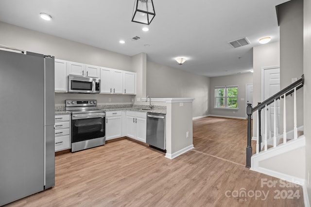 kitchen featuring light hardwood / wood-style flooring, white cabinets, and stainless steel appliances