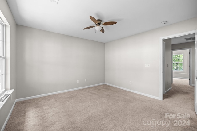 carpeted spare room featuring ceiling fan