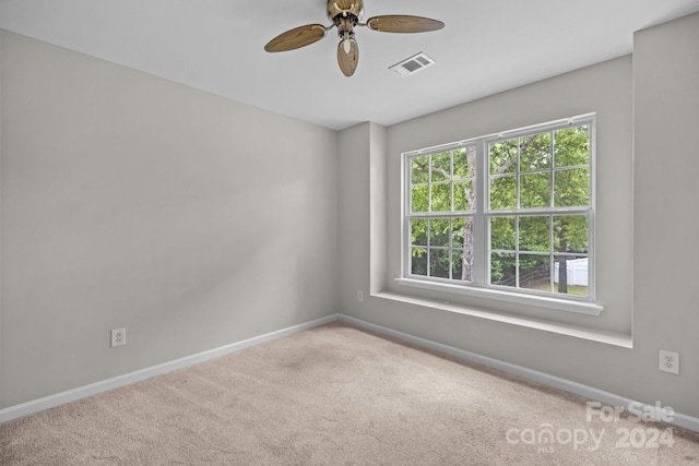 empty room featuring carpet floors, a wealth of natural light, and ceiling fan