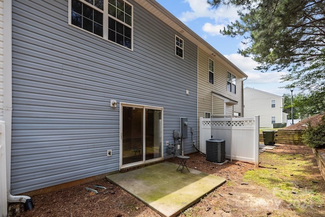 rear view of property with cooling unit and a patio