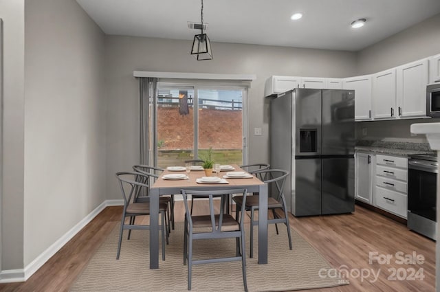 kitchen featuring light stone counters, white cabinets, stainless steel appliances, and light hardwood / wood-style floors