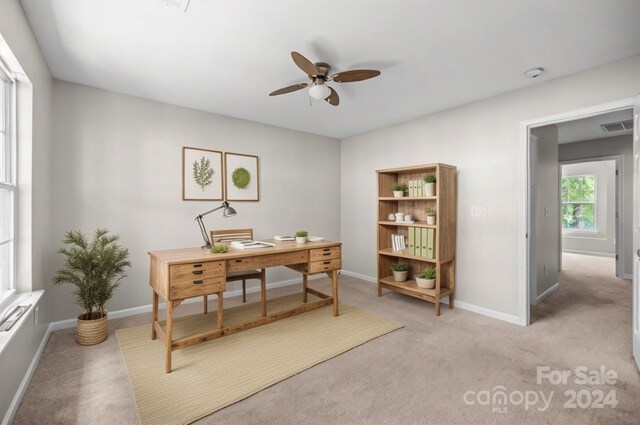 office space with light carpet and ceiling fan