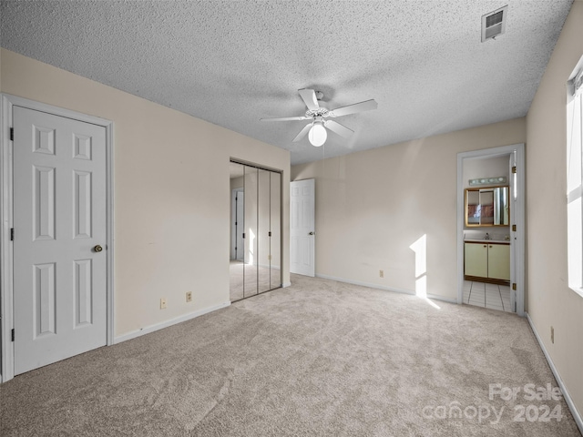 carpeted spare room featuring ceiling fan, a healthy amount of sunlight, and a textured ceiling