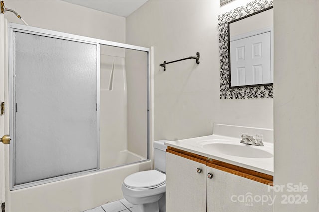 full bathroom featuring vanity, bath / shower combo with glass door, toilet, and tile patterned floors