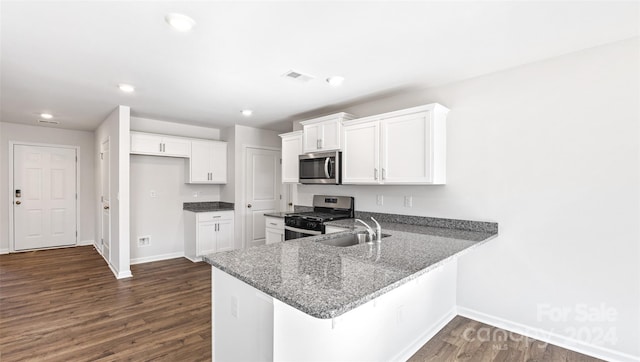 kitchen featuring kitchen peninsula, dark wood-type flooring, white cabinetry, and appliances with stainless steel finishes