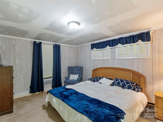 bedroom with carpet flooring, wooden walls, and a baseboard radiator