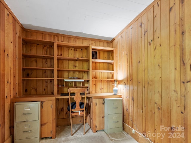 carpeted office space featuring wooden walls