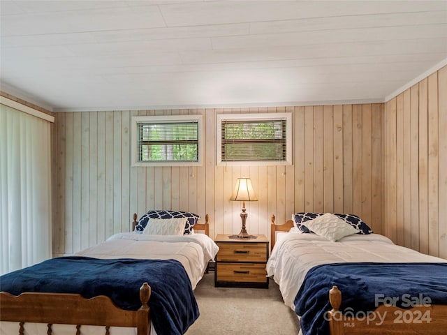 carpeted bedroom featuring wooden walls