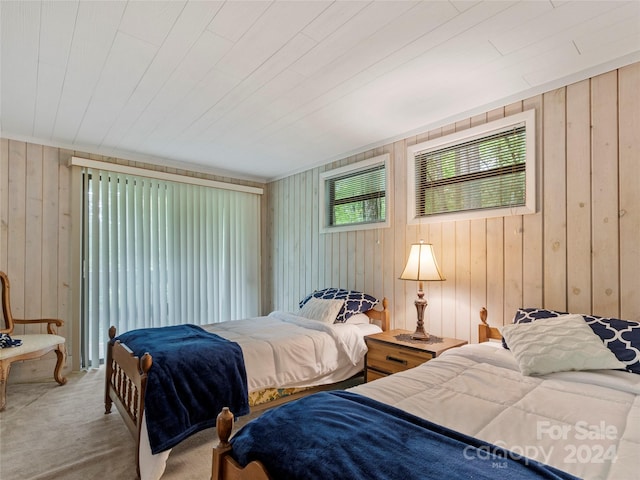 bedroom featuring carpet flooring and wooden walls