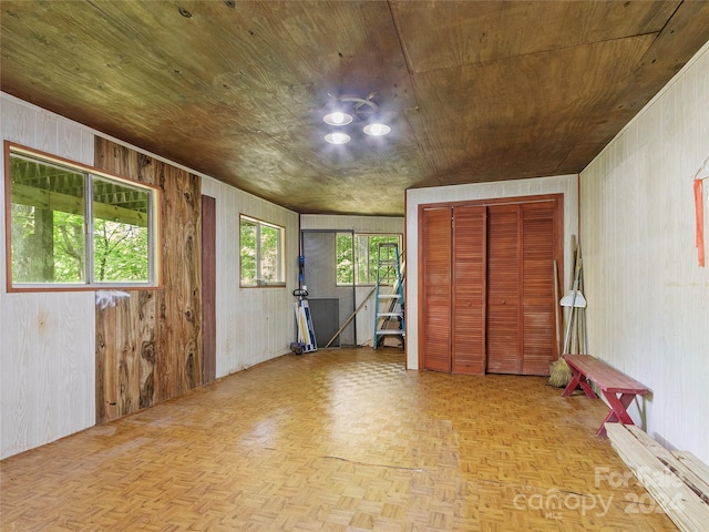 interior space featuring wood walls, parquet flooring, and wood ceiling