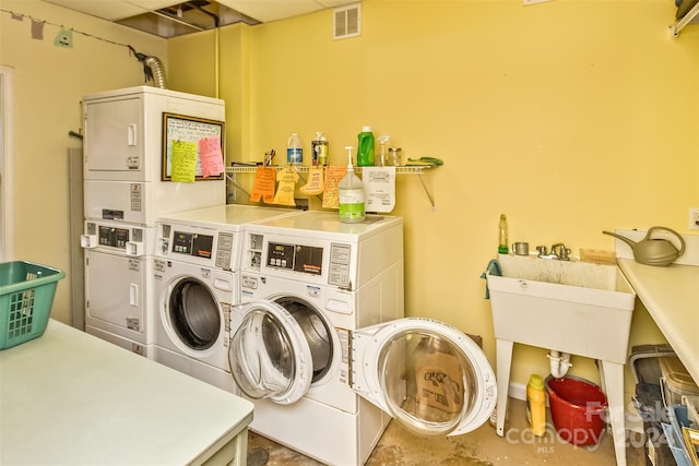 washroom with stacked washer and clothes dryer, washer and clothes dryer, and sink