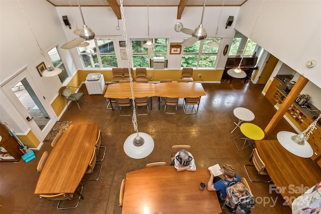 living room with plenty of natural light, a towering ceiling, and ceiling fan