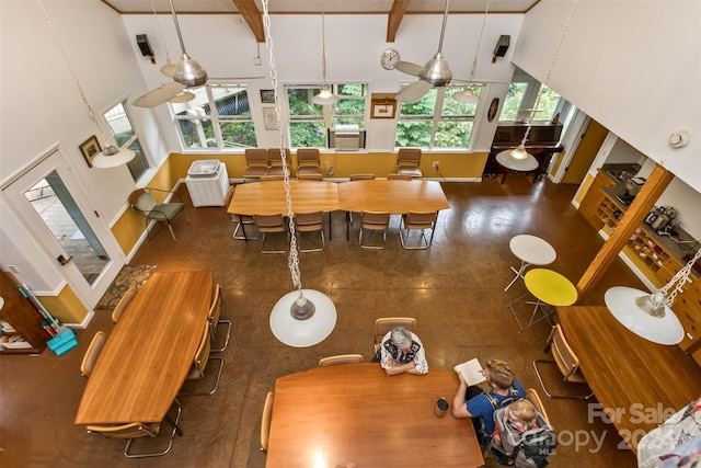 dining space with high vaulted ceiling and beamed ceiling