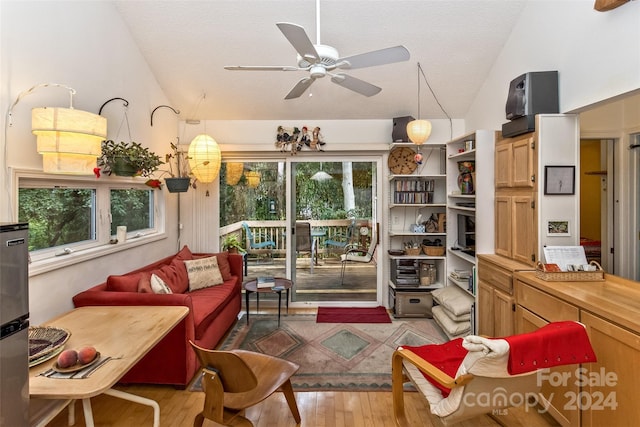 living room with light hardwood / wood-style floors, high vaulted ceiling, a wealth of natural light, and ceiling fan