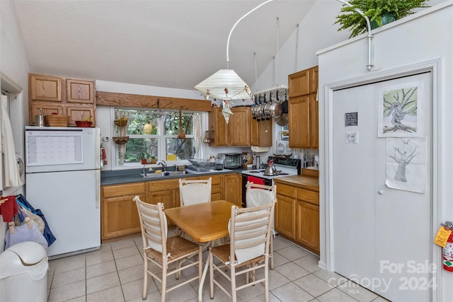 kitchen with sink, white refrigerator, and light tile patterned floors