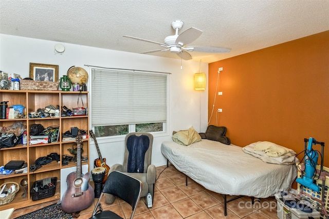 tiled bedroom featuring a textured ceiling and ceiling fan