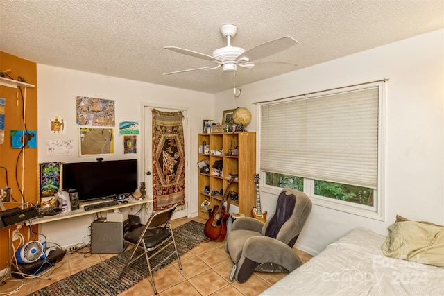 home office with a textured ceiling, light tile patterned floors, and ceiling fan