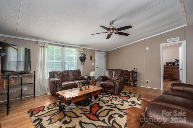 living room with ceiling fan, light wood-type flooring, crown molding, and a textured ceiling