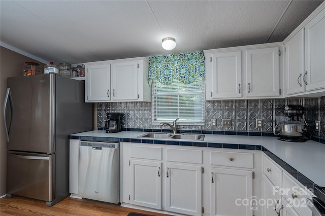 kitchen featuring sink, white cabinetry, appliances with stainless steel finishes, and light hardwood / wood-style flooring