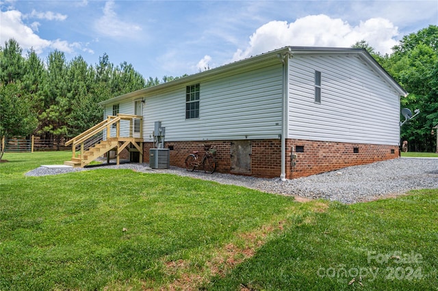 rear view of property with a lawn and central AC unit