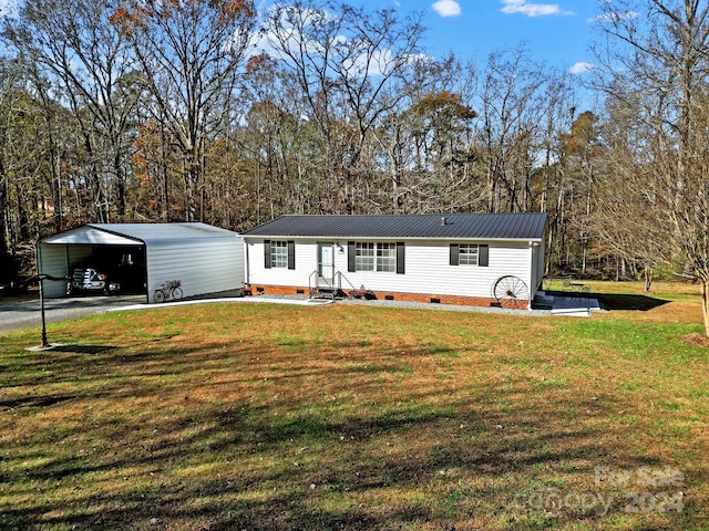 manufactured / mobile home featuring a carport and a front yard