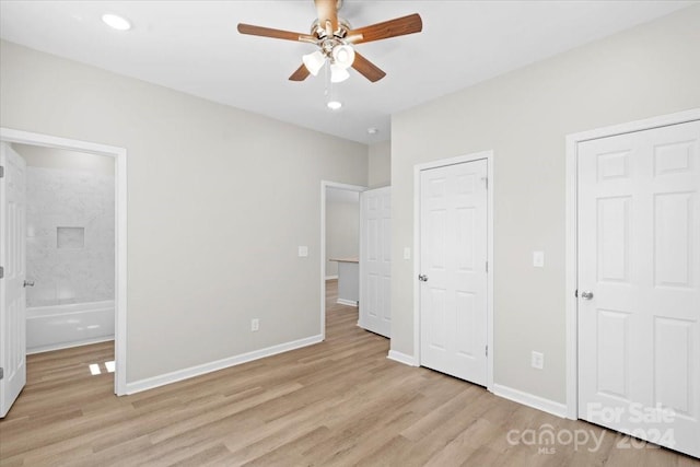 unfurnished bedroom with ensuite bathroom, ceiling fan, and light wood-type flooring