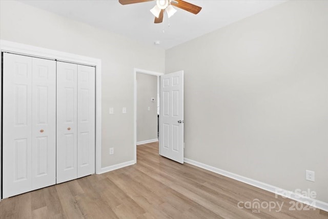 unfurnished bedroom featuring ceiling fan, a closet, and light hardwood / wood-style floors