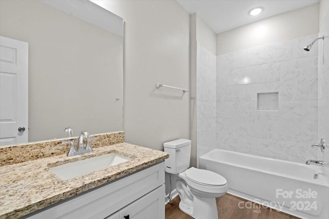 full bathroom with toilet, vanity, wood-type flooring, and tiled shower / bath