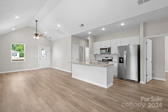 kitchen with white cabinets, light hardwood / wood-style flooring, light stone countertops, an island with sink, and appliances with stainless steel finishes