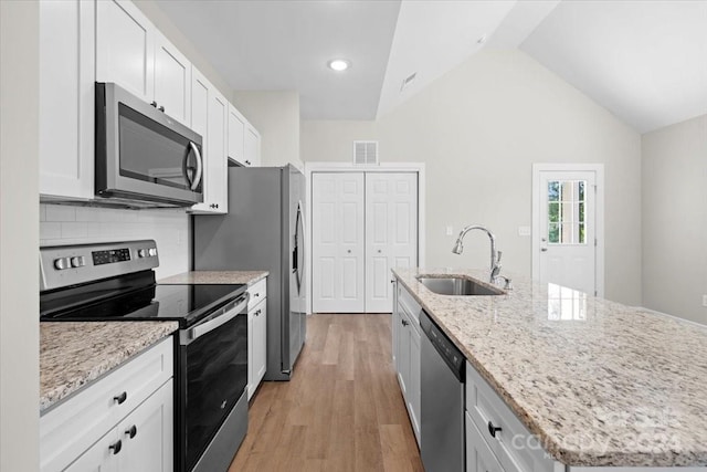 kitchen with white cabinetry, sink, stainless steel appliances, and a center island with sink