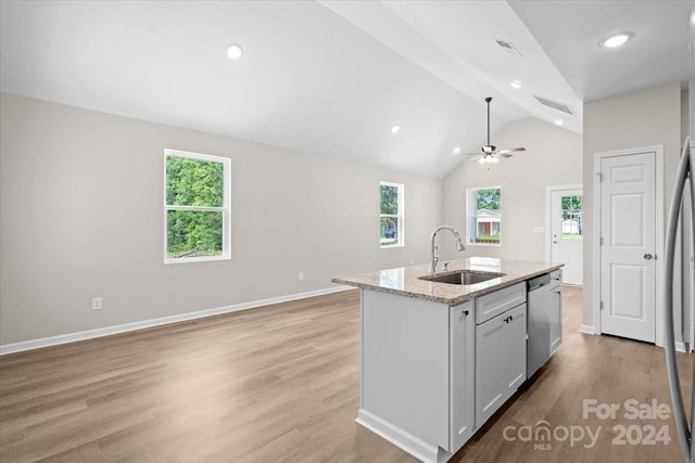 kitchen with dishwasher, a wealth of natural light, lofted ceiling, and sink