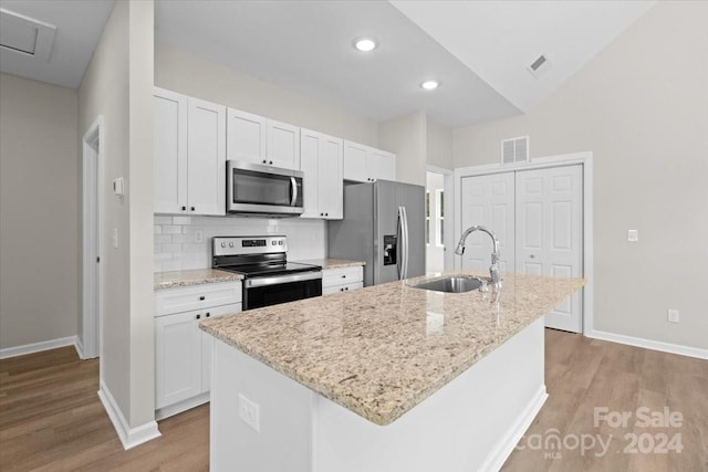 kitchen featuring an island with sink, stainless steel appliances, white cabinetry, and sink