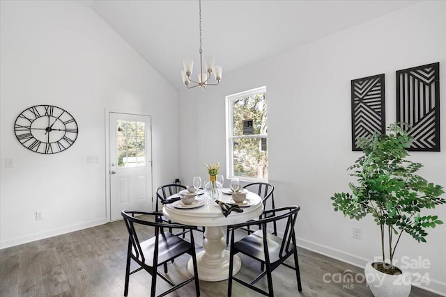 dining room with a wealth of natural light, high vaulted ceiling, dark wood-type flooring, and a notable chandelier