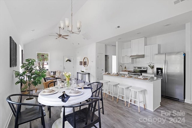 dining room featuring ceiling fan, light hardwood / wood-style flooring, and high vaulted ceiling