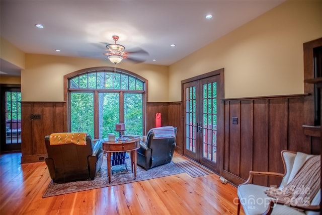 sitting room featuring ceiling fan, french doors, and light wood-type flooring